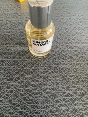 King's Gambit Eau de Parfum från AQC - King's Gambit Eau de Parfum från AQC. Flaskan är genomskinlig med silverfärgat lock och enkel, modern etikett. Parfymen har en ljusgul vätska och flaskan är tillverkad i glas med metallock. Doften är utvecklad i EU och tillverkad av Aquarius Cosmetic.