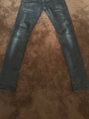 Dondup  slim fit jeans - Säljer ett par mörkblå slim fit jeans med lätt slitna detaljer och smal passform. Jeansen har klassisk femficksdesign och är tillverkade i stretchigt material för extra komfort. Perfekta för dig som gillar en tajtare look.  Dondup jeans , storlek 30