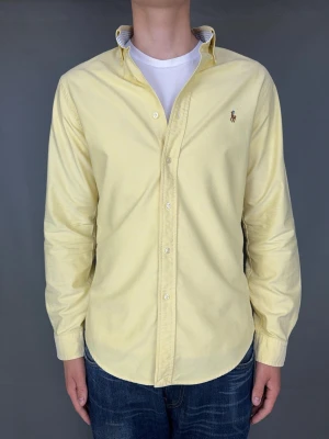 Ralph Lauren skjorta - Ralph Lauren skjorta Märke: Polo Ralph Lauren Storlek: M Passform: Slimfit Färg: Gul Skick: Mycket bra Beskrivning: utan defekter, möjligtvis någon liten fläck som inte syns.  Modellen på bilden: 183 cm / 75 kg
