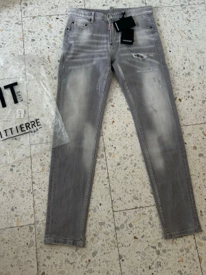 Dsquared2 Jeans - gråa med slitningar - Riktigt feta dsq jeans i en fin grå färg med några slitningar som får jeansen att se speciella ut. Original tags medföljer. Pris kan diskuteras vid snabb affär.