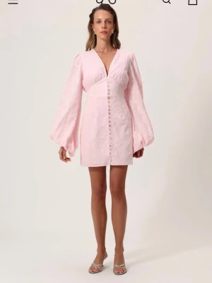 Ljusrosa kort klänning med puffärm - Rosa klänning från adoore, ej använd och har prislapp kvar. Säljer pågrund av att jag hellre vill ha en lång modell. Liten i storlek 
