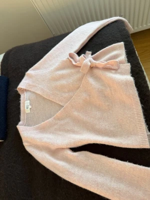 Ljusrosa omlottkofta Monki - Säljer denna supersöta tröjan från ginatricot. Den är superfin på och säljer den då den blivit för kort för mig. Den är i jättefint skick och är  använd ett fåtal gånger❤️❤️❤️