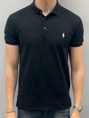 Ralph lauren piké - Märke: Ralph Lauren Modell: Slim Fit Stretch mesh Färg: Svart Storlek: M Material: Stretch mesh, mjuk och formsittande  Skick: fint skick, utan defekter  Klassisk Ralph Lauren-piké i slim fit med stretch för bekväm passform. Perfekt sommarplagg som funkar både avslappnat och lite snyggare.