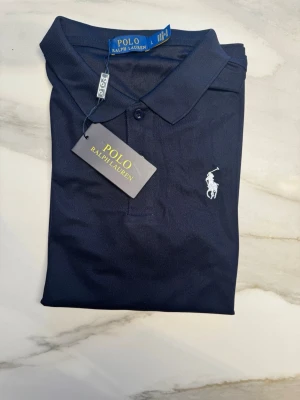 Ralph Lauren Piké - Mörkblå Ralph Lauren Piké med vit häst logga i storlek L (passar runt 170-176). Kom privat med frågor och prisförslag😊
