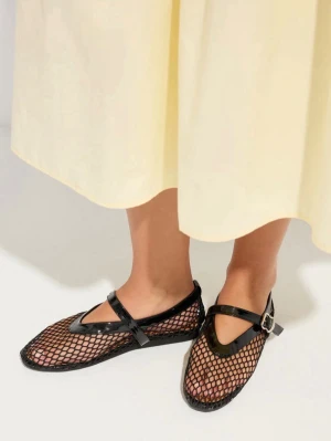Svarta mesh ballerinaskor i läder - Unika ballerinaskor i svart mesh med lackdetaljer och justerbart spänne över foten. Skorna har rundad tå och en cool nätstruktur som ger en trendig look. Perfekta för dig som vill sticka ut med din stil. Äkta läder, helt nya!