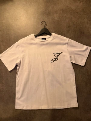 Vit t-shirt från jacquemus - Vit t-shirt från jacqmues med svart broderad logga på bröstet. Klassisk rund halsringning och korta ärmar. Tillverkad i mjuk bomull för en skön känsla och enkel stil. Passar M me
