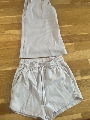 Ljusrosa loungewear-set linne & shorts - Säljer ett ljusrosa loungewear-set med ribbat linne och matchande shorts. Shortsen har resårmidja och dragsko för skön passform samt fickor på sidorna. Perfekt för chill dagar hemma. Materialet känns mjukt och bekvämt mot huden.