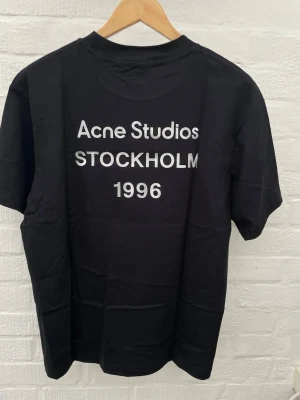 Acne Studios t-shirt - Svart t-shirt från Acne Studios i storleken M. Tröjan är helt ny utan några defekter. Mått: Längd: 68. Axelbredd: 48 