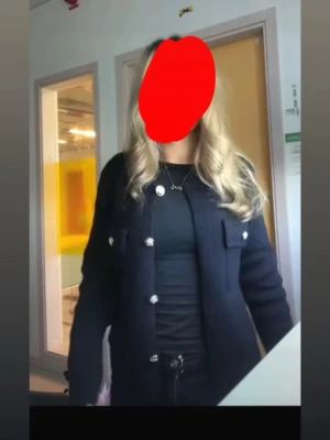 Svart bouclékofta från Missäy - Stilren svart bouclékofta från Gina Tricot med dekorativa silvriga knappar framtill och på ärmsluten. Koftan har två bröstfickor med lock och rak passform. Perfekt att bära över en topp för en trendig look.