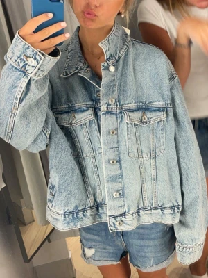 Oversized ljusblå jeansjacka - Säljer en jättefin oversized ljusblå jeansjacka. Jackan har två bröstfickor med lock och knappar framtill. Skulle säga att den passar xs-M! Finns inte längre i butik!