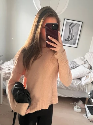 Coral stickad tröja - Mysig coral stickad tröja med rund halsringning och långa ärmar. Tröjan har ribbade muddar vid ärmslut och nederkant samt en avslappnad passform. Perfekt för att hålla sig varm under kyliga dagar. Passar S och XS.