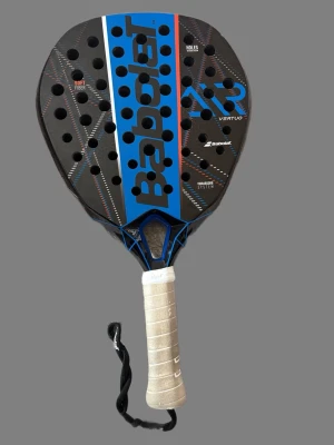 Babolat Air Vertuo padelracket - Säljer ett Babolat Air Vertuo padelracket i svart med blå och röda detaljer. Racket har hål i träffytan, vit lindad greppyta och handledsrem. Tillverkat i kompositmaterial med soft fiber och vibrasorb system för bättre spelkänsla. Ny pris 1300kr