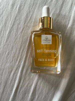 Miqura self-tanning drops Face & Body - Bronzing self-tanning drops från Miqura för ansikte och kropp. Kommer i en genomskinlig fyrkantig glasflaska med pipett och guldfärgat lock. Ger en solkysst glow och innehåller 25 ml. Perfekt för att bygga upp en naturlig bränna.