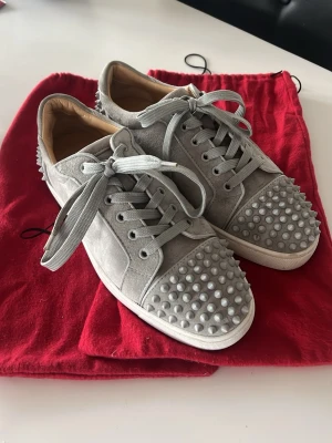 Gråa Louboutin sneakers - Riktigt feta Christian louboutin skor som är knappt använda (2x max) Säljes pga bytt ut stilen helt, tyckte dem var riksfeta men måste tyvärr sälja dem då de ej kommer till användning. Det som medföljer är dustbags och dem är köpta i FB gruppen ”High End Market” av en legitim säljare. Skorna är riktiga!