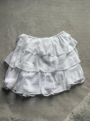Vit volang kjol - Supersöt vit skort med flera lager volanger och elastisk midja. 
