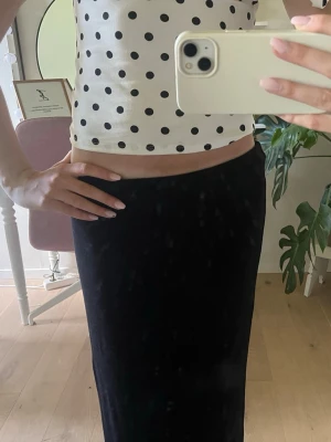 Svart långkjol i enkel design - Säljer en svart långkjol med rak passform. Säljs eftersom den inte kommer till andvändning. Modellen har en slits längst ner som ni ser på sista bilden. Står S men kjolen töjbar och passar  mig som brukar ha XS i kjolar. Fråga gärna om ni har fler frågor💞