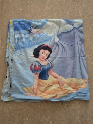 Påslakan - Säljer ett påslakan med motiv av Snövit och Askungen från Disney. Färgerna går i blått, gult, rött och vitt med detaljer som slott, fåglar och blommor. Materialet är mjukt bomullstyg och passar perfekt till barnrummet för den som gillar klassiska prinsessor.