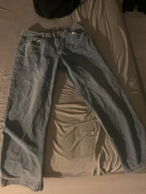 Ljusblå raka baggy jeans  - Säljer ett par ljusblå jeans med rak passform och klassisk femficksdesign. Jeansen har normal midja och är tillverkade i denim. Perfekta för en avslappnad och trendig stil.