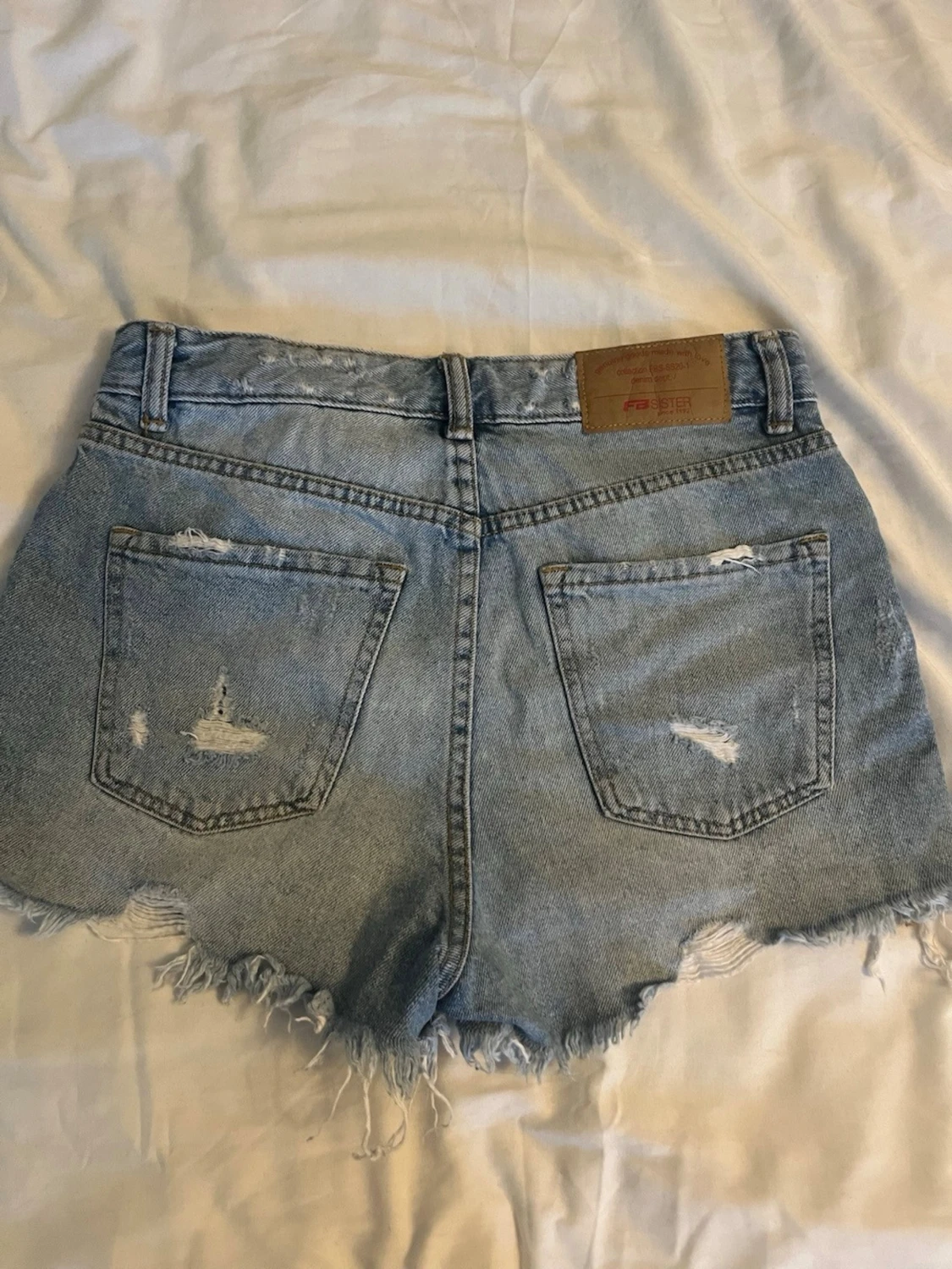 Högmidjade ljusblå jeansshorts - 1