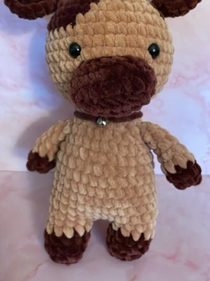 Mjukisdjur i beige och brunt - Söt mjukisdjur i beige och mörkbrunt plyschmaterial med stora svarta ögon och en liten bjällra runt halsen. Perfekt som gosedjur eller dekoration. Tjockt, fluffigt tyg och gulliga detaljer på öron, nos och tassar.