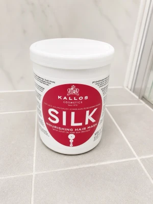Kallos Silk hårinpackning 1000 ml - Kallos Silk Nourishing Hair Mask är en närande hårinpackning med olivolja och silkesprotein. Kommer i en stor vit plastburk med röd etikett. Perfekt för att ge håret extra fukt och glans.