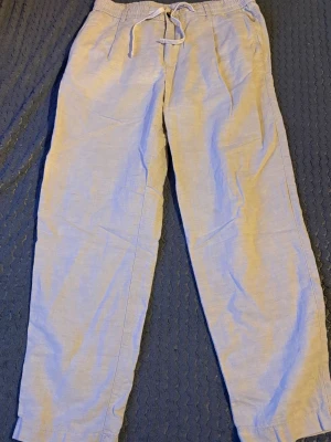  linnebyxor från Mango - Snygga beiga linnebyxor med avslappnad passform och elastisk midja med dragkedja . Byxorna har sidfickor fram och knäppbara bakfickor. Perfekta för en chill och luftig stil under varma dagar.