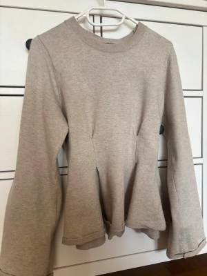 Beige stickad tröja Gina Tricot - En fin beige stickad topp som knappt har blivit använd, super fin volang nedtill💕