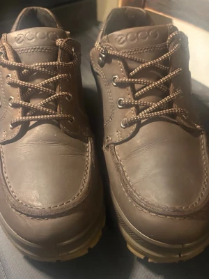 Bruna ECCO loafers i läder - Säljer ett par bruna loafers från ECCO i robust läder med grov sula och snörning. Skorna har GORE-TEX-märke på sidan och är perfekta för dig som gillar klassisk stil med funktionella detaljer. Snygga kontrastsömmar och diskret ECCO-logga på plösen.