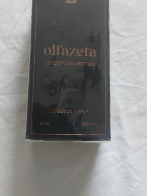 Olfazeta Luxury Collection parfym - Exklusiv parfym från Olfazeta Luxury Collection. Flaskan rymmer 50 ml extrait de parfum och kommer i en elegant svart förpackning med kopparfärgade detaljer. Perfekt för dig som gillar lyxiga och unika dofter.