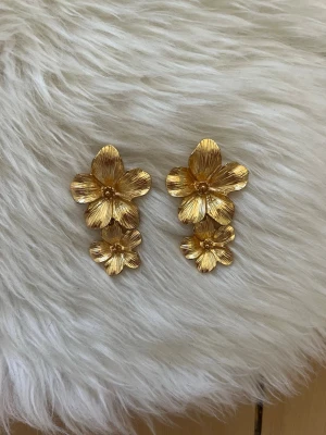 Guldiga blomörhängen i metall - Säljer nu dessa assnygga örhängen, säljer då jag använder silver💘 köpta på Plick för längesen, kan diskutera pris💘 