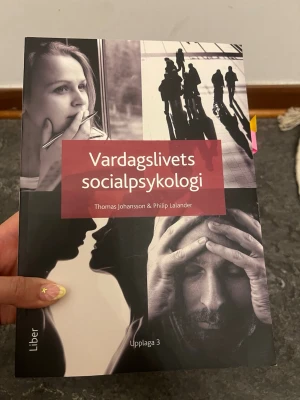 Vardagslivets socialpsykologi bok - Kurslitteratur: Vardagslivets socialpsykologi av Thomas Johansson & Philip Lalander, upplaga 3. Boken har ett omslag i svart, vitt och rött med foton och grafiska element. Perfekt för dig som pluggar psykologi eller samhällsvetenskap.