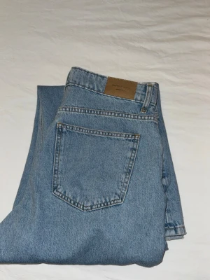 Blåa raka jeans från Weekday - Säljer ett par klassiska blå jeans från Gina Tricot i rak modell. Jeansen har hög midja, fem fickor. Perfekta för en avslappnad och trendig stil.