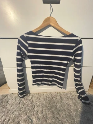 Marinblå och vit randig långärmad topp - Fin randig tröja med bred hals. Från Kappahl med snitt längst ner vid hanlederna. 