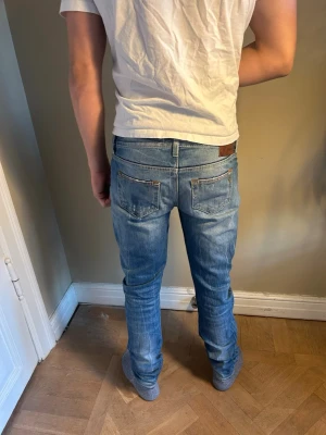 Ljusblå Dondup jeans W27 sitter som W29 - SiSnygga ljusblå dondup jeans med  diskreta slitningar framtill. SJeansen har normal midja och raka ben. Perfekta för en avslappnad och trendig stil. 