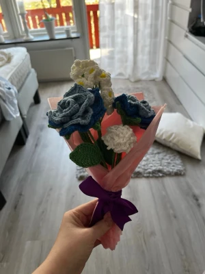 Handgjord bukett med virkade blommor - 💐 Handgjord virkad bukett – Medium 💐  Unik bukett med virkade rosor och små blommor, perfekt som present eller dekoration som håller för alltid 🤍  • Storlek: Medium   • Färger: Blå, vit & grön   • Inslagen redo att ges bort 🎁   • 100% handgjord   📩 Skriv till mig här eller på Instagram för custom orders 