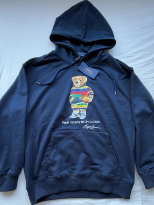 Helt ny Polo  Ralph Lauren hoddie - En helt ny Mörkblå hoodie från Ralph Lauren med Polo Bear-tryck på bröstet. Storlek S men passar även M. Pris kan dirkuteras vid snabb affär.