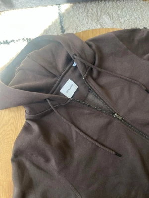 Brun ziphoodie från Jack & Jones - Tjena👋 Säljer en brun hoodie från Jack & Jones med dragkedja framtill, huva med dragsko och två fickor🤩 Tillverkad i mjukt bomullsmaterial som är skönt mot huden✌️ Perfekt för en avslappnad och stilren look👌 messa gärna vid frågor📩