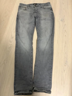 Gråa jeans  - Snygga grå jeans med rak passform och klassisk femficksdesign. Jeansen har en diskret tvättad look och är tillverkade i denim. Perfekta för en avslappnad stil.