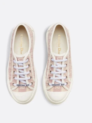 Dior rosa låga sneakers med logga - Snygga låga sneakers från Christian Dior i rosa och vitt med tydlig Dior-logga på canvasmaterial. Skorna har vita snören, gummisula och metall-detaljer vid snörningen. Perfekt för dig som vill ha en exklusiv och trendig look.