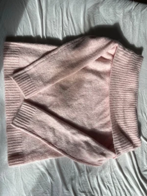 Ljusrosa stickad tröja Gina Tricot - Mysig ljusrosa stickad tröja från Gina Tricot med bred ribbstickad kant vid hals, ärmslut och nederkant. Perfekt för dig som gillar en enkel och stilren look. Tröjan är mjuk och har en klassisk passform.