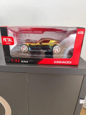 Metallisk bilmodell 1:32 från Xinhaodi - Säljer en snygg bilmodell i metall från Xinhaodi i skala 1:32. Bilen har en cool regnbågsskimrande färg och detaljerade fälgar. Kommer i originalförpackning med fönster så man ser bilen tydligt. Perfekt för samlare eller som dekoration.