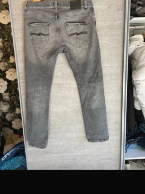 Nudie jeans - Märke: Nudie Jeans.                                                Storlek: 32/32.                                                          Modell: grim Tim.                                                         Färg: grå med svarta detaljer.                                   Litet hål i skrevet. bara att kontakta om du har mer frågor🤩