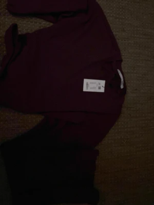 Vinröd omlottopp med knyt - Trendig vinröd omlottopp med långa ärmar och snygg knytning framtill. Toppen har en croppad passform och är perfekt för dig som vill ha en cool och stilren look. Tillverkad i mjukt tyg som känns skönt mot huden.