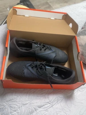 Phantom 6 low acad FG/MG är använda typ 1/3 gånger - Säljer ett par svarta fotbollsskor från Nike med klassisk snörning och dobbar för bra grepp på planen. Skorna har en stilren design med diskreta vita detaljer och är tillverkade i syntetmaterial som ger bra känsla och kontroll på bollen.