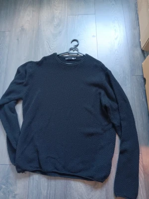  stickad tröja - En enkel och stilren svart stickad tröja med rund halsringning och lång ärm. Tröjan har en diskret struktur i stickningen som ger en snygg textur. 