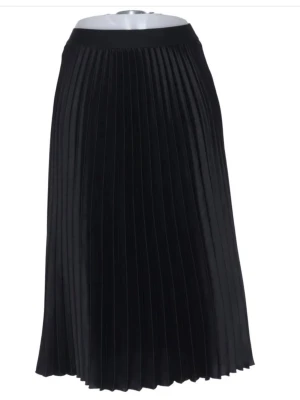Svart plisserad långkjol - Snygg svart långkjol med plisserad design som ger ett stilrent och trendigt intryck. Kjolen har en hög midja och ett mjukt, följsamt material som faller fint. Perfekt att matcha med en croppad topp eller stickad tröja.