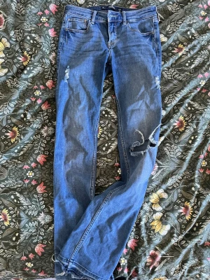 Blå slitna jeans med hål - Säljer ett par blå jeans med slitningar och stora hål på benen, jeansen har raka ben med lite tajtare pass form (inte skinny) passar mig som bär 36 men säljer för de inte längre kom till någon användning🩵