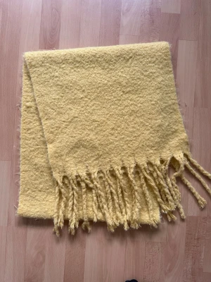 Gul mjuk halsduk fransar - Tjock och supermjuk stickad halsduk i en fin, gul nyans. Den har en skön textur och långa, tvinnade fransar i ändarna. Superskön verkligen!✨