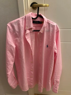 Rosa skjorta från Polo Ralph Lauren - Ralph Lauren-skjorta i nyskick, helt oanvänd. Storlek XS, men passar även dig som vanligtvis har storlek S. Klassisk modell och perfekt skick