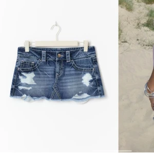 Blå jeanskjol med slitningar Gina - Säljer en kort jeanskjol i blå denim med  slitningar och fransig nederkant. 